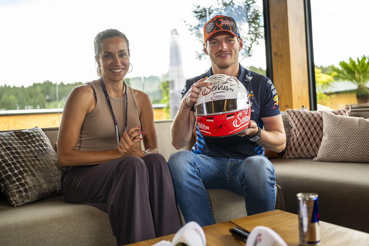 Max Verstappen und Andrea Schlager mit dem ServusTV-Helm